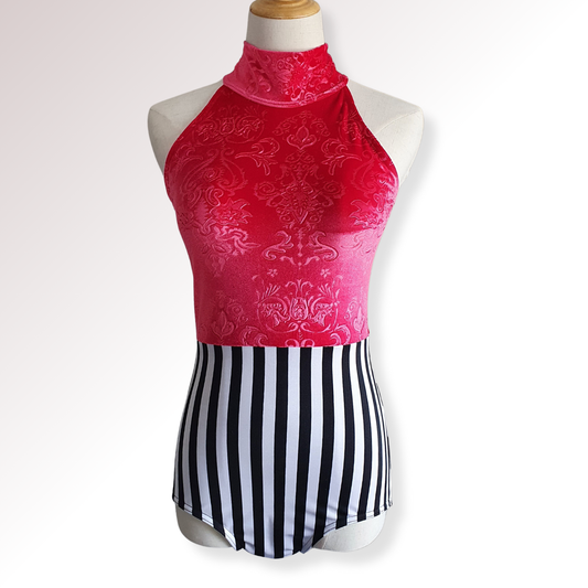 Red patterned top and black and white striped skirt on a mannequin against a white background